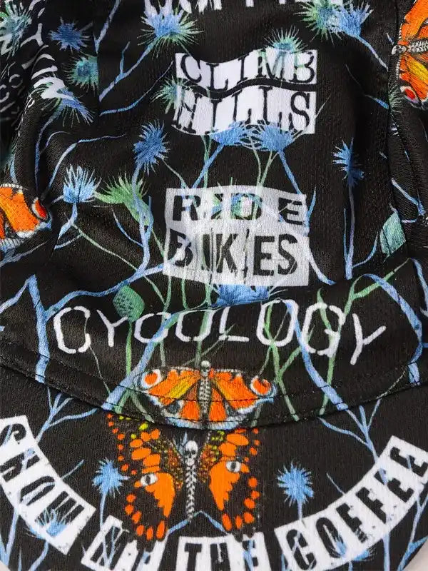 Cycling jersey with 'Climb Hills Ride Bikes' print, butterflies, and floral design on black fabric