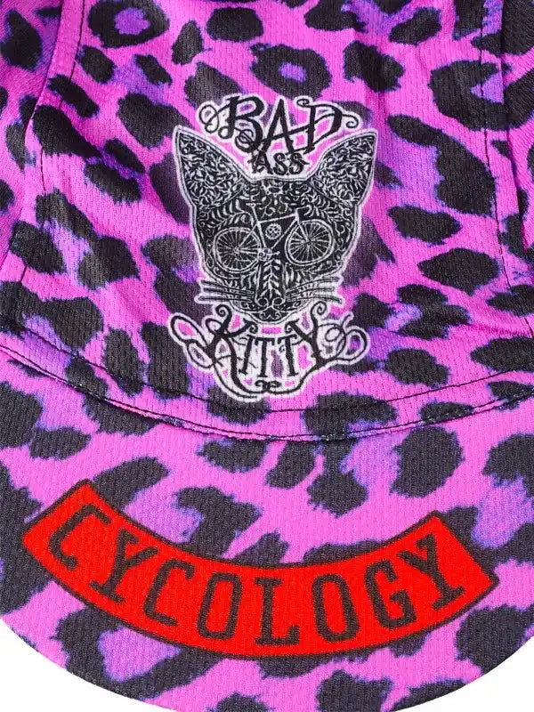 Pink leopard print cycling jersey with 'Bad Ass Kitty' cat graphic and red 'Cycology' logo