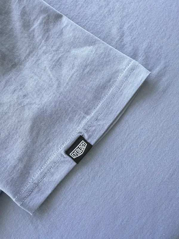 Light gray cycling jersey sleeve with black brand tag, high-quality fabric detail