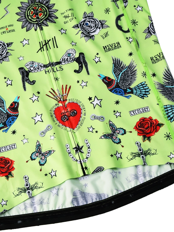 Close-up of a green fabric with tattoo-style designs including roses, hearts, and birds.