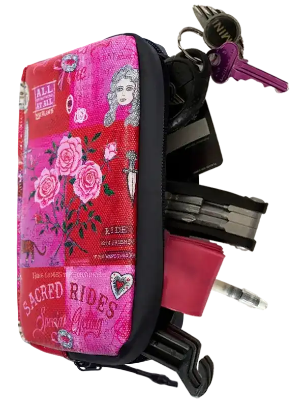 Pink floral cycling key pouch with 'Sacred Rides' print, holding keys and tools for bike commuters