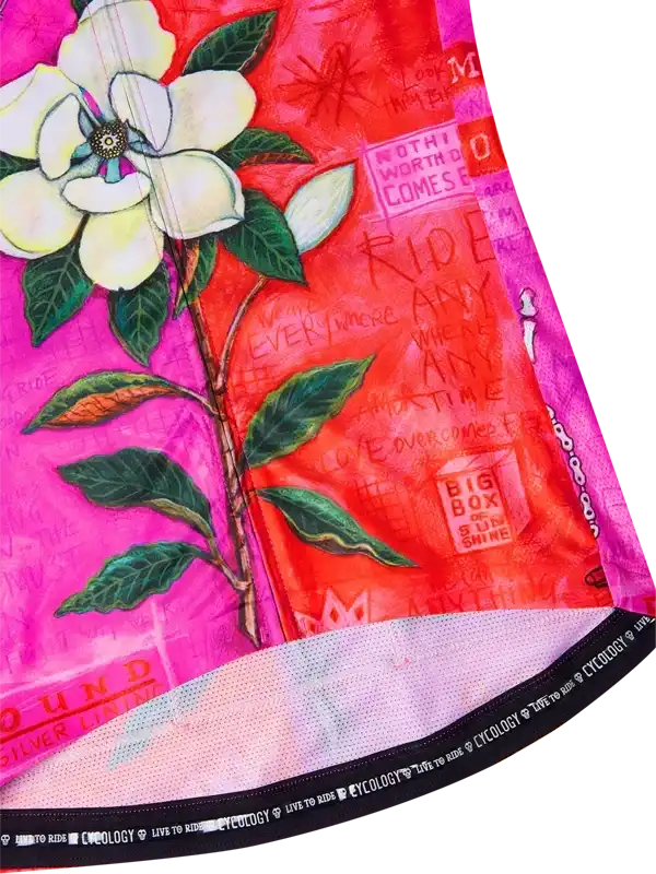 Vibrant pink and red cycling jersey with white flower print and motivational text, featuring mesh hem and brand tag.