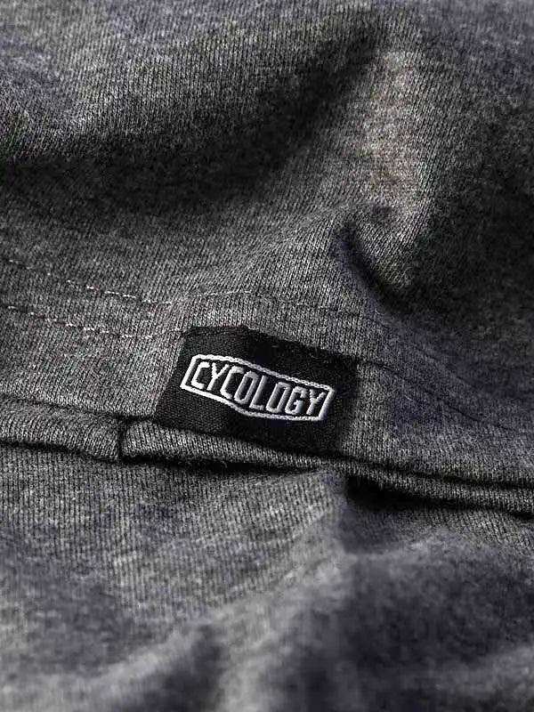 Cycology brand tag on dark gray cycling apparel fabric, showcasing quality stitching and design detail.
