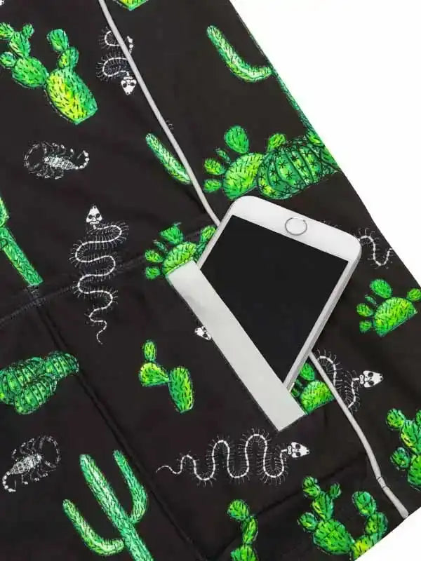 Black cycling shorts with green cactus and white snake print, phone in side pocket