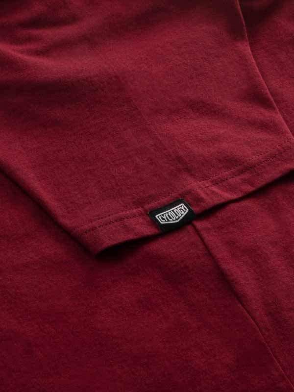 Cycology brand tag on deep red cycling apparel fabric, showcasing quality stitching and design detail