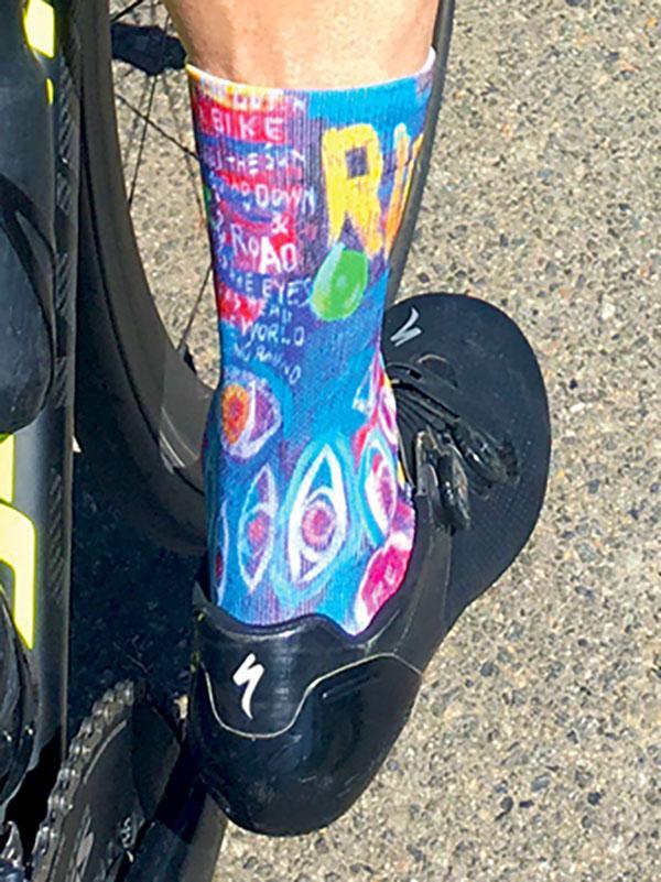 Colorful cycling socks with bold graphics worn with black cycling shoes on a bike