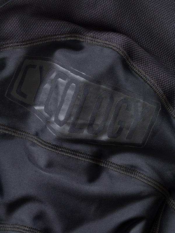 Close-up of black cycling jersey with subtle 'CYCOLOGY' logo, high-quality fabric detail