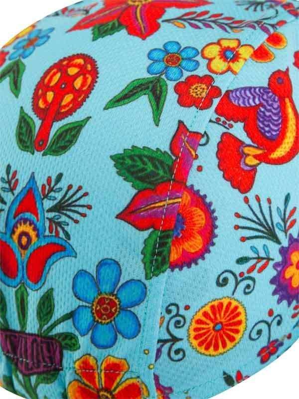 Vibrant floral and bird pattern on light blue cycling fabric, featuring colorful flowers and embroidered details.