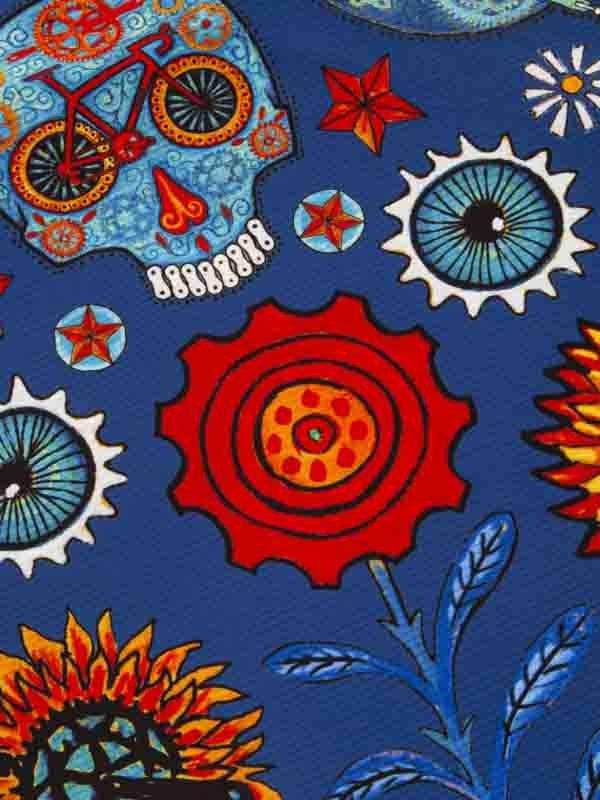 Vibrant cycling-themed fabric with skulls, gears, sunflowers, and bikes on blue background