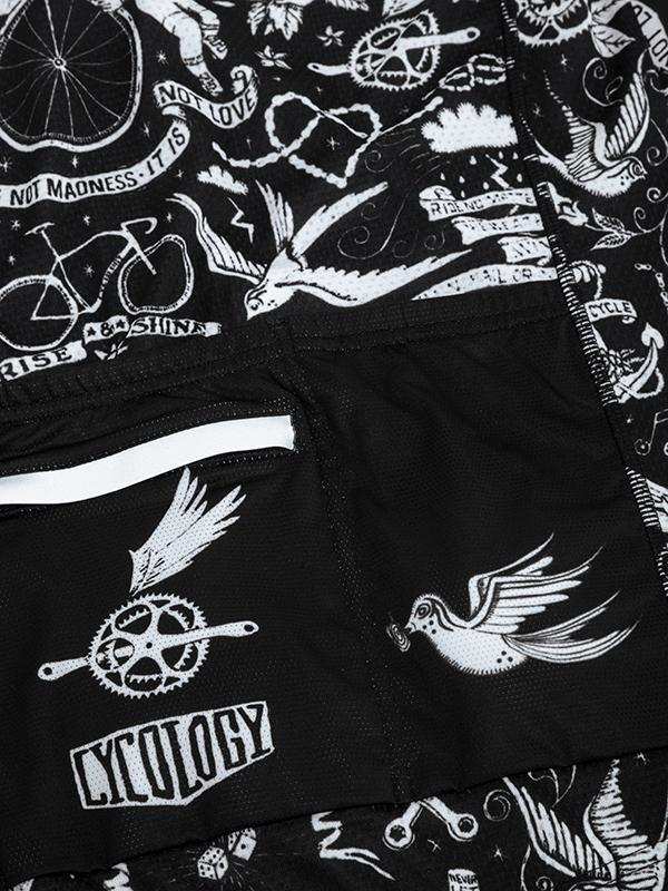 Black cycling shorts with white tattoo-style bird, bike, and gear graphics, featuring 'CYCOLOGY' branding