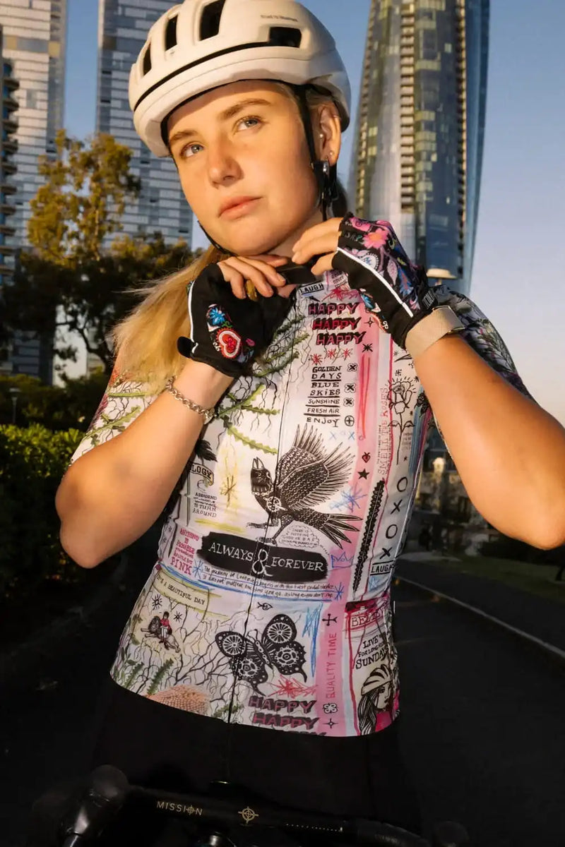 Woman in colorful graphic cycling jersey and helmet, urban city backdrop, stylish bike wear