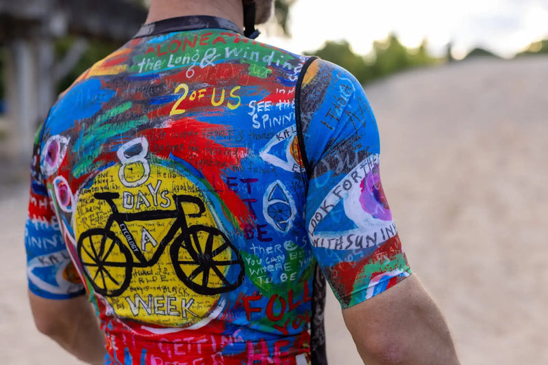 Colorful men's cycling jersey with bold graphics and text, featuring a bike design and motivational phrases for road rides.