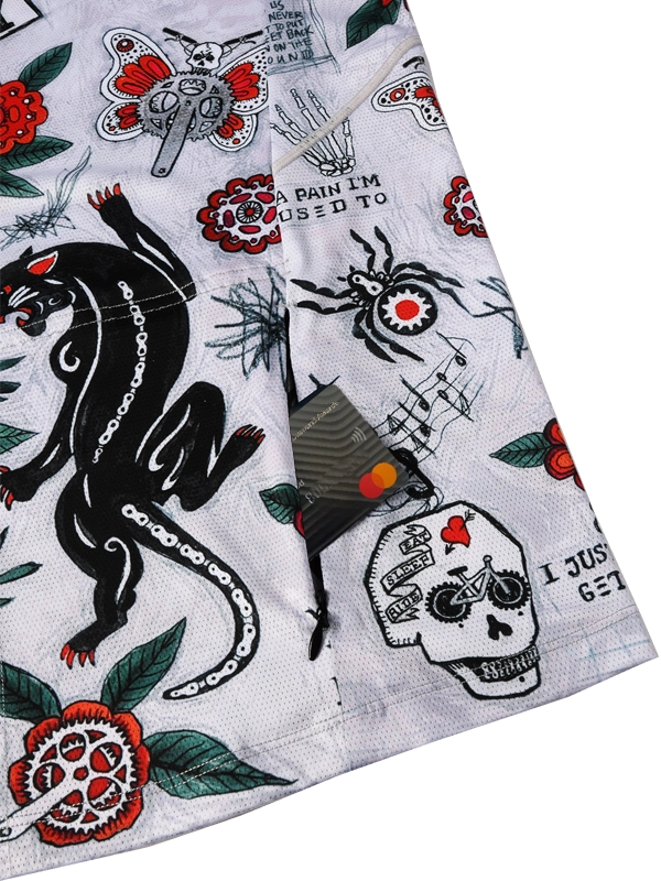 Close-up of a fabric with tattoo-style designs including a panther, skull, and text 