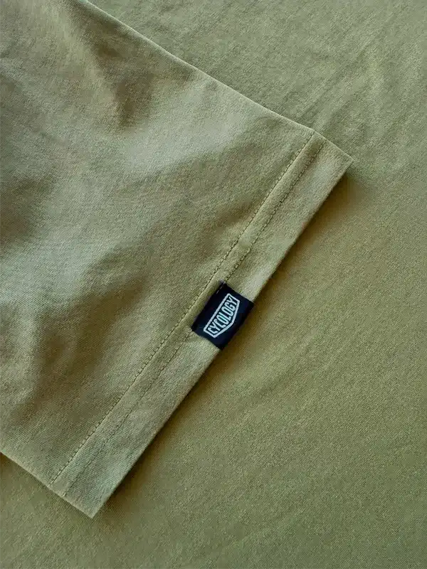 Olive green cycling jersey sleeve with Cycology brand tag, showcasing quality fabric and stitching detail.