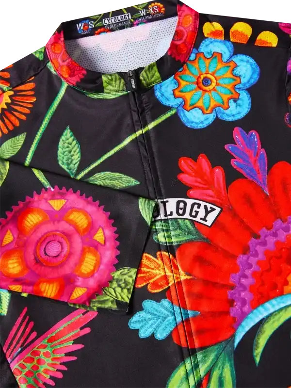 Vibrant floral cycling jersey with colorful blooms and 'OLOGY' logo on black fabric, designed for performance.