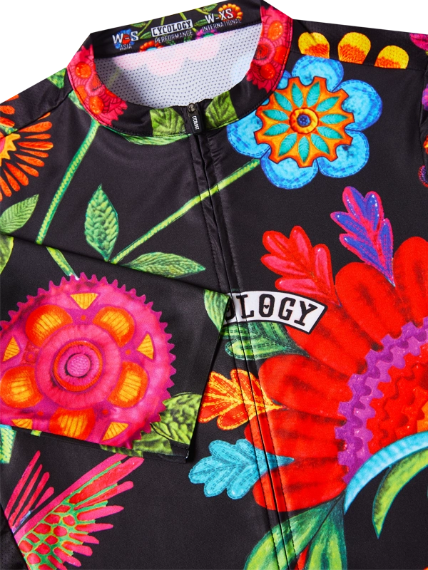 Colorful cycling jersey with floral designs and visible brand logo on a black background