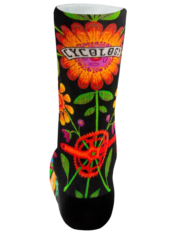 A single crew cycling sock with a black background and a vibrant, multicolored floral pattern, shown against a plain white background.