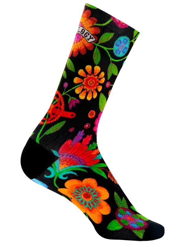A single crew cycling sock with a black background and a vibrant, multicolored floral pattern, shown against a plain white background.