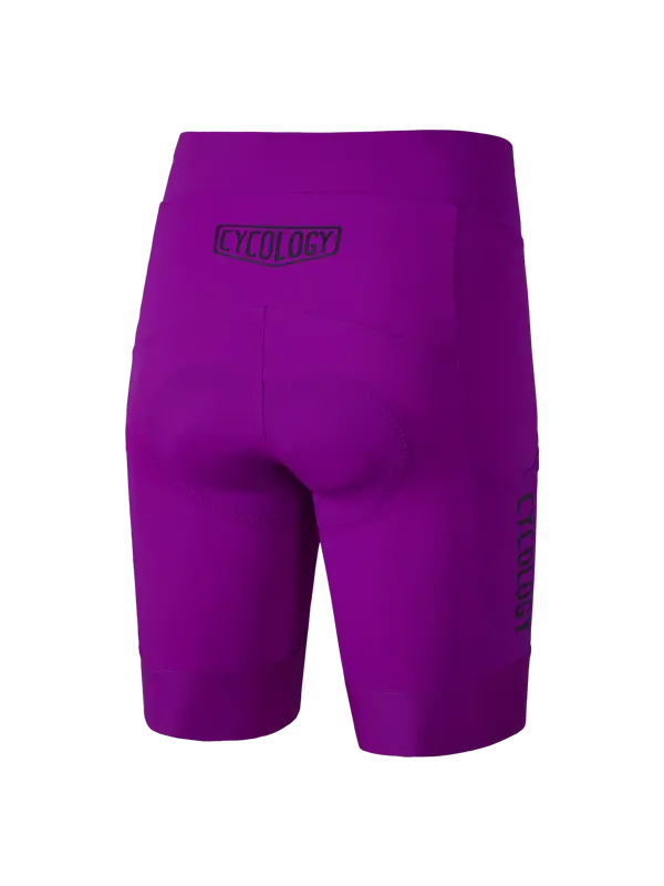 Purple cycling shorts with a padded rear area, featuring a 'CYCOLOGY' logo on the back waistband and 'CYCOLOGY' printed vertically on the left leg, shown against a plain white background.