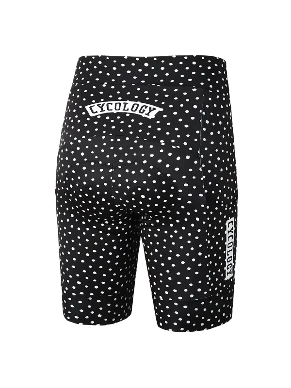 Women's black cycling cargo shorts with a white polka dot pattern and a vertical white CYCOLOGY logo on the lower left leg, shown against a plain white background.
