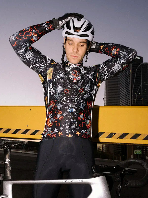 Person wearing a black winter cycling jersey with intricate designs and tiger on a black background