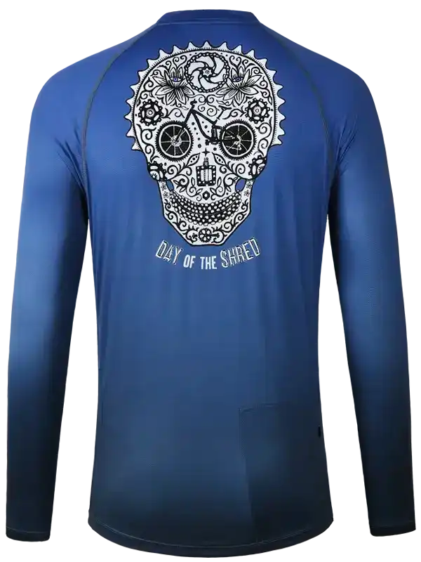 Blue long-sleeve cycling jersey with sugar skull and 'Day of the Shred' graphic, ideal for men's and women's bike rides.