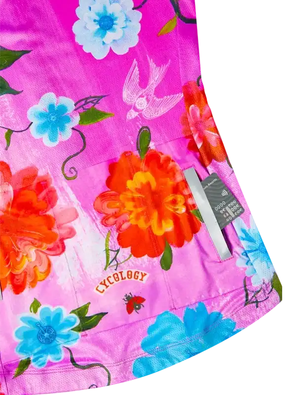 Vibrant pink cycling jersey with floral and bird print, featuring Cycology logo and rear pockets