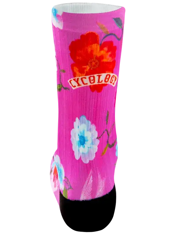 A single crew sock with a bright pink background, featuring a large red flower, a white and blue flower, green stems, and the word 'CYCOLOG' in white text on a red banner near the upper calf.