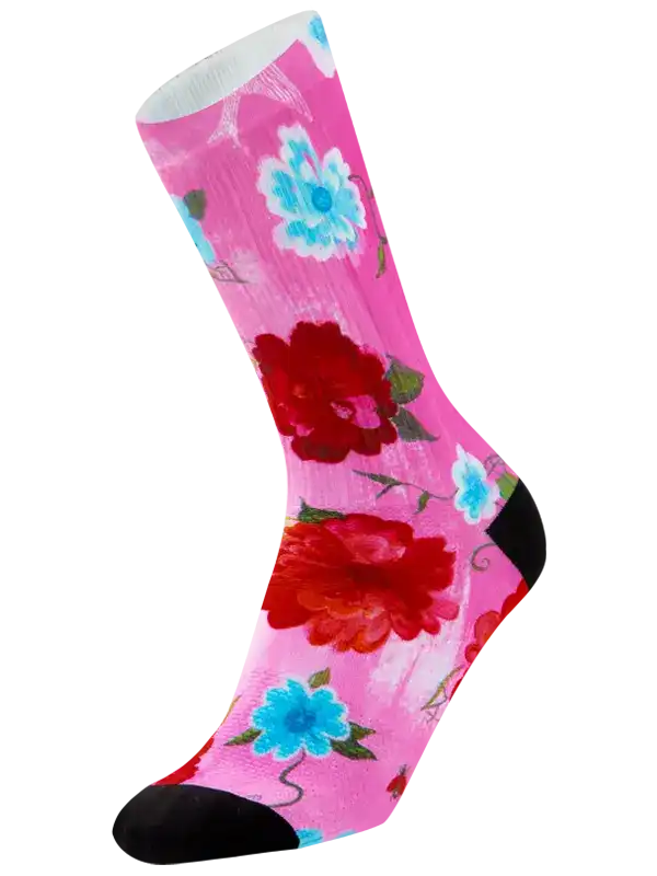 A single crew  cycling sock with a vibrant pink background featuring a floral print of red and light blue flowers with green leaves, finished with solid black heels and toes.