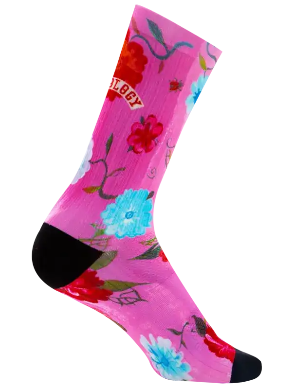A single crew sock with a vibrant pink background featuring a colorful floral pattern in red, light blue, and green, with a solid black heel and toe.