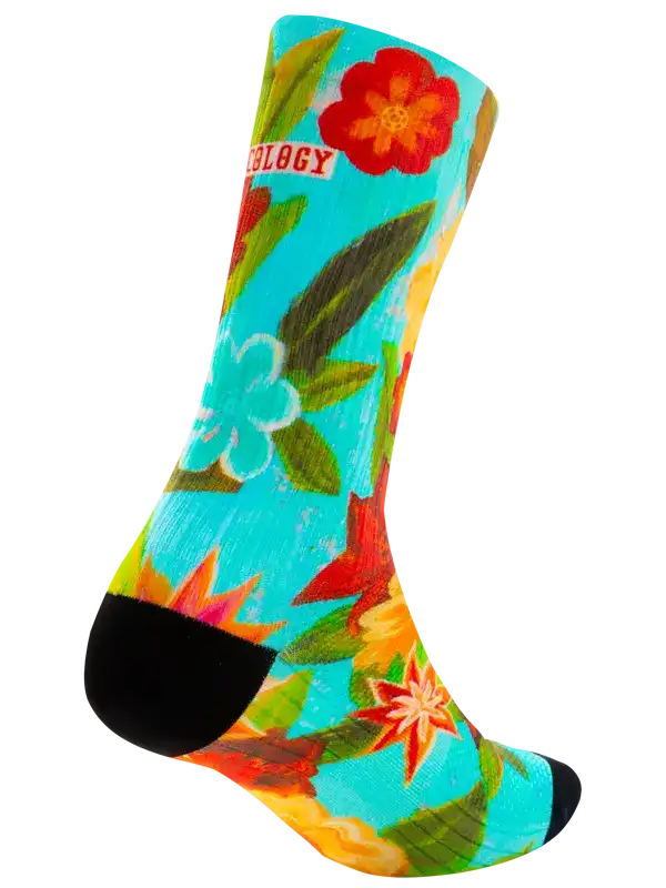 A single crew cycling sock with a vibrant, painterly floral pattern in turquoise, red, orange, yellow, and green, featuring solid black toe and heel sections.