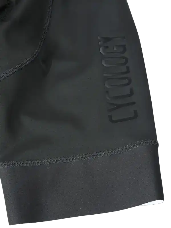 Close-up of Dark Grey Men's cycling bib shorts with a ribbed cuff and embossed CYCOLOGY