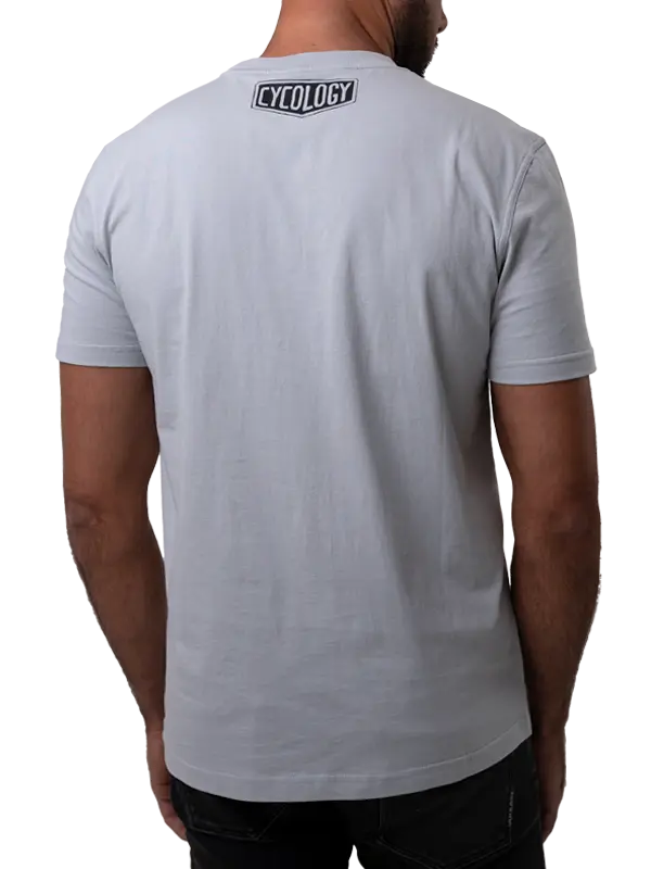 Person wearing a gray t-shirt with 'Cycology' branding on the back, on a white background