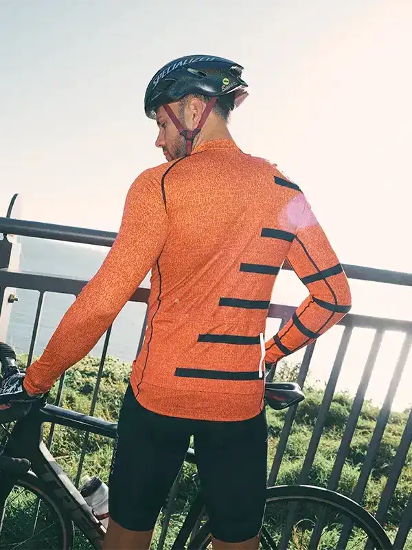Men's orange cycling jersey with black stripes, worn with helmet and bike outdoors