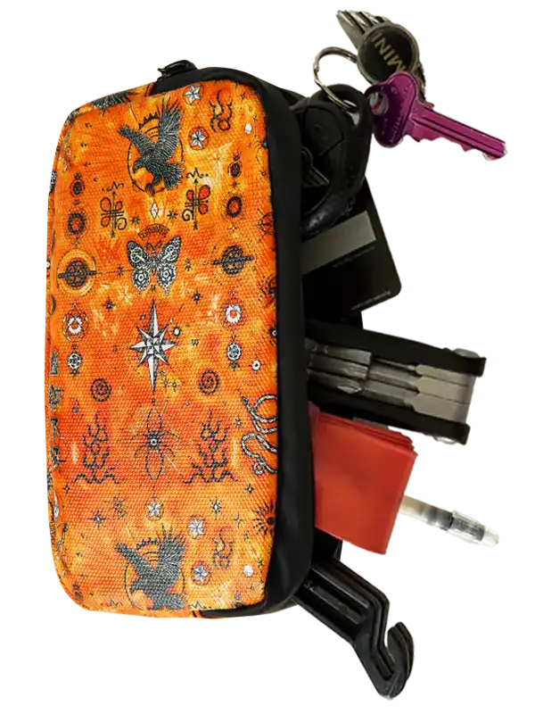 Nomad Cycling Wallet by Cycology Clothing with orange cosmic pattern holding keys and tools