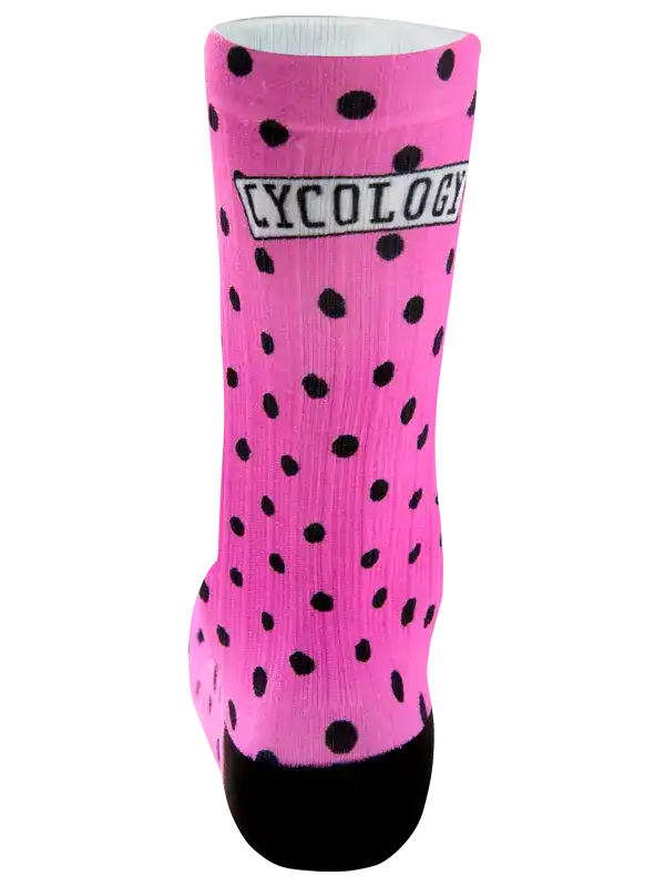 A single bright pink crew sock with black polka dots, a black toe, and a black heel, featuring a white rectangular patch with the word 'CYCOLOGY' in black text.