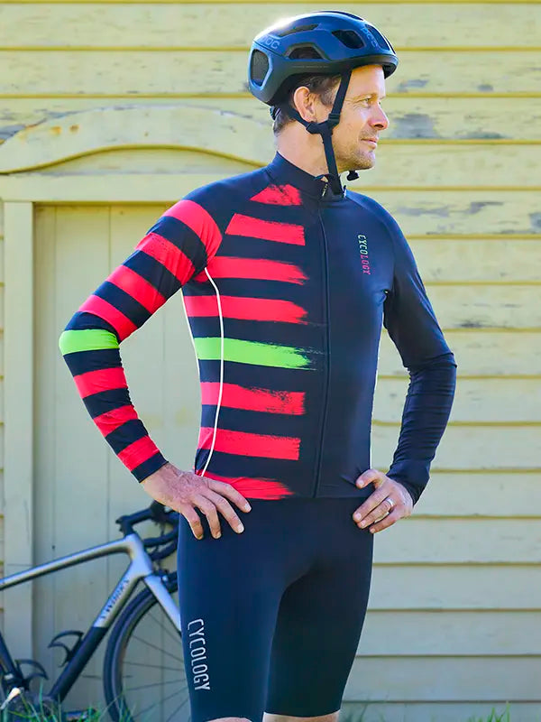 Homme portant un kit cycliste coloré noir et rouge avec un casque, 