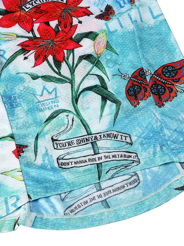 Colorful fabric with red flowers, green leaves, and text on a blue background
