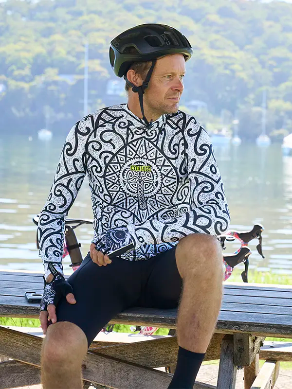 Man sitting on a bench wearing a patterned Zanzibar Men's White Long Sleeve Summer Cycling Jersey