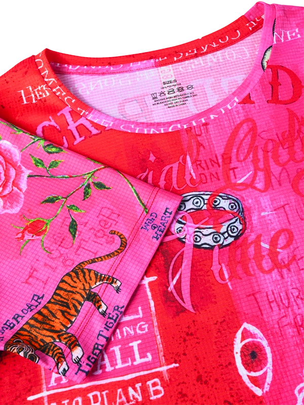 Close-up of a pink and red  t shirt with graphic designs and text.