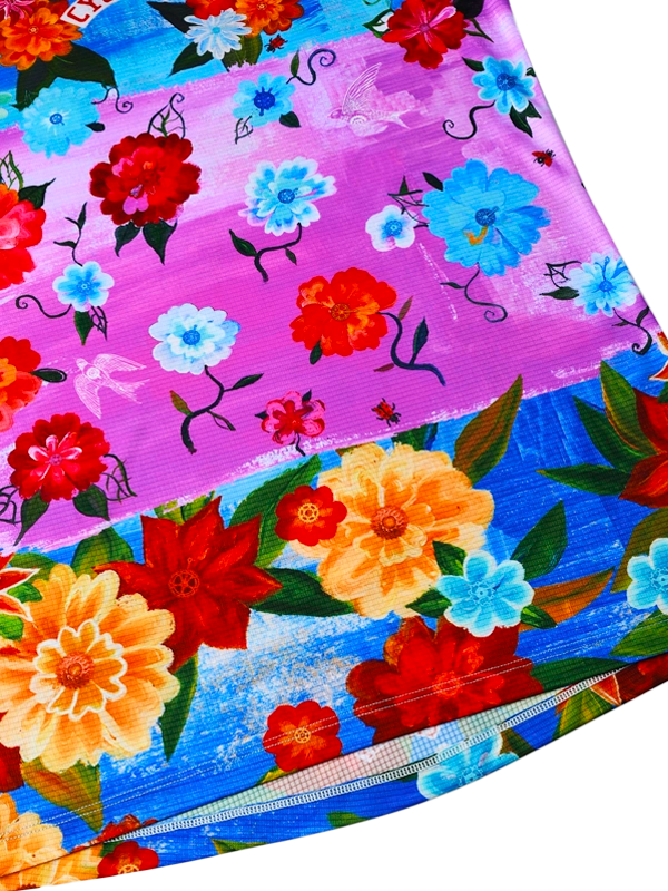 Colorful women's floral tech  t-shirt with red, yellow, and blue flowers on a multi coloured background