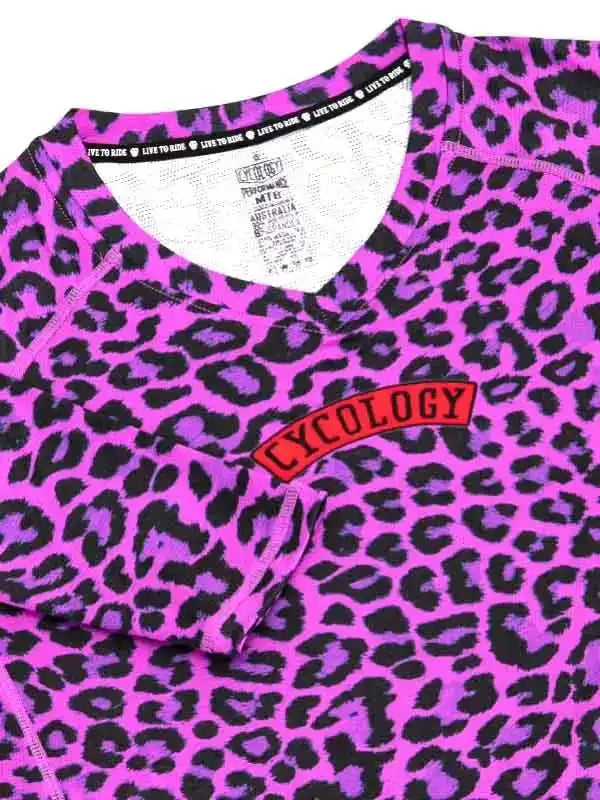 Vibrant pink leopard print cycling jersey with red Cycology logo, ideal for women's bike wear