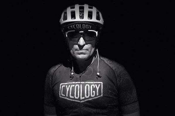 Cyclist wearing Cycology jersey and helmet, ready for a ride in stylish cycling gear
