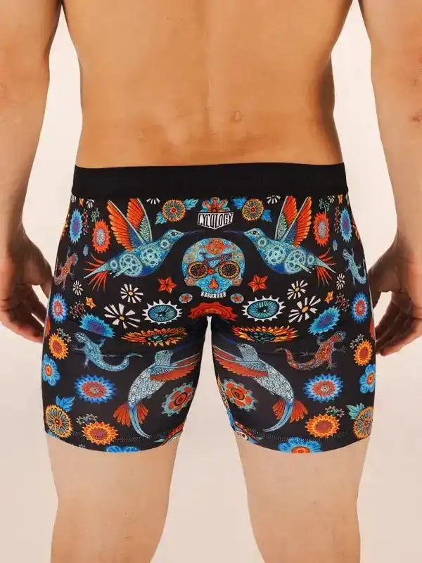 Men's cycling shorts with vibrant hummingbird and skull print, colorful floral patterns on black fabric