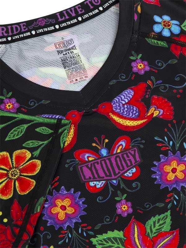 Vibrant floral and bird print women's cycling jersey with 'Live to Ride' neck tag and performance fabric details