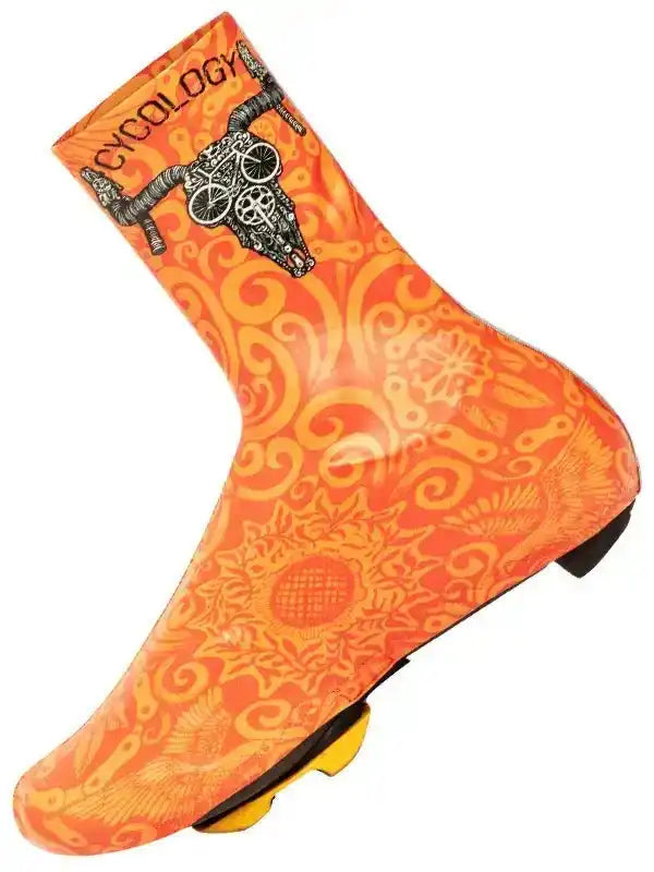 Orange cycling shoe cover with skull and bike design, featuring swirl patterns and 'CYCOLOGY' branding